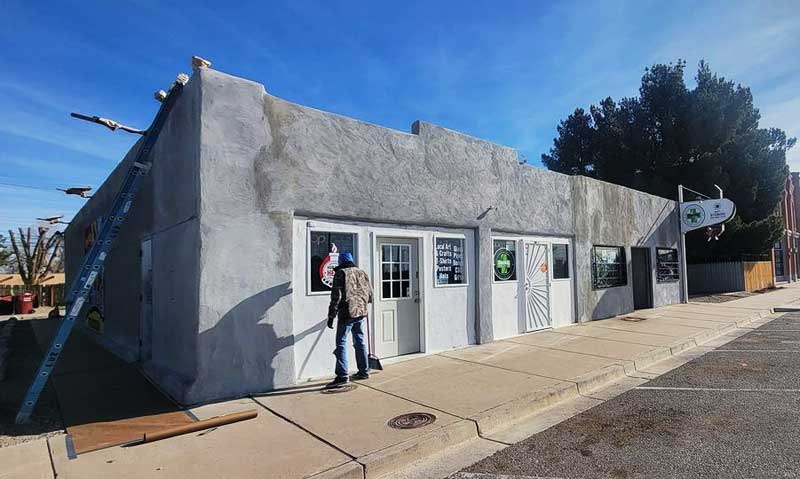 Prepping exterior of commercial building stucco for paint by CM All About Paint in Belen